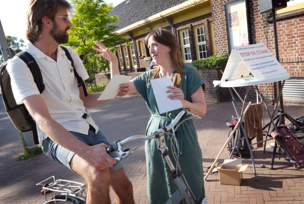 Personen op straat praten Een vrijwillger van Adem Vrij aan het IJ spreekt met een buurtbewoner
