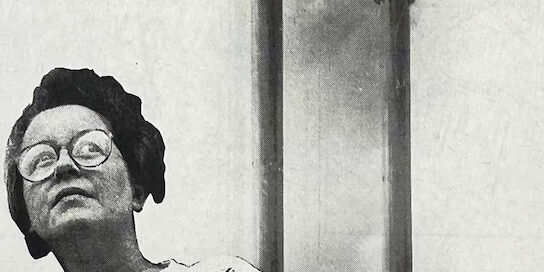 Foto van Ilja Lodeer met op de achtergrond twee fabriekspijpen waar vieze rookwolken uitkomen